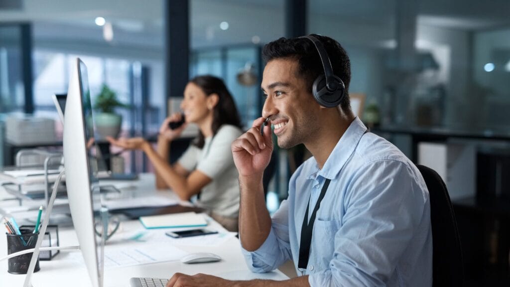 A diverse group of customer service representatives working at a call center, engaging with customers through phone and chat. The image highlights multilingual support, AI-powered automation, and personalized customer experiences in a global business environment.