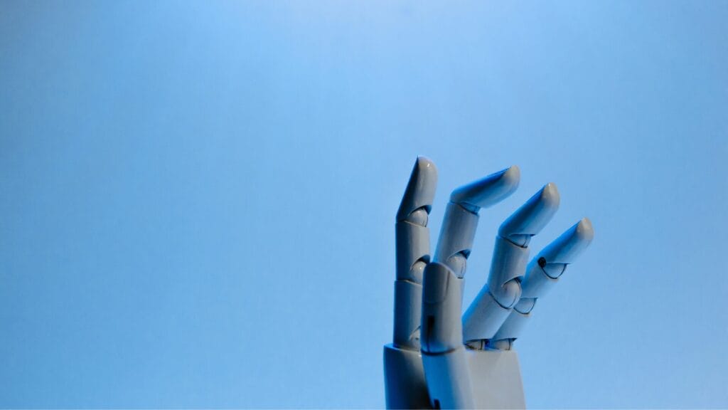 A robotic hand reaching upward against a blue background, symbolizing AI and technology.