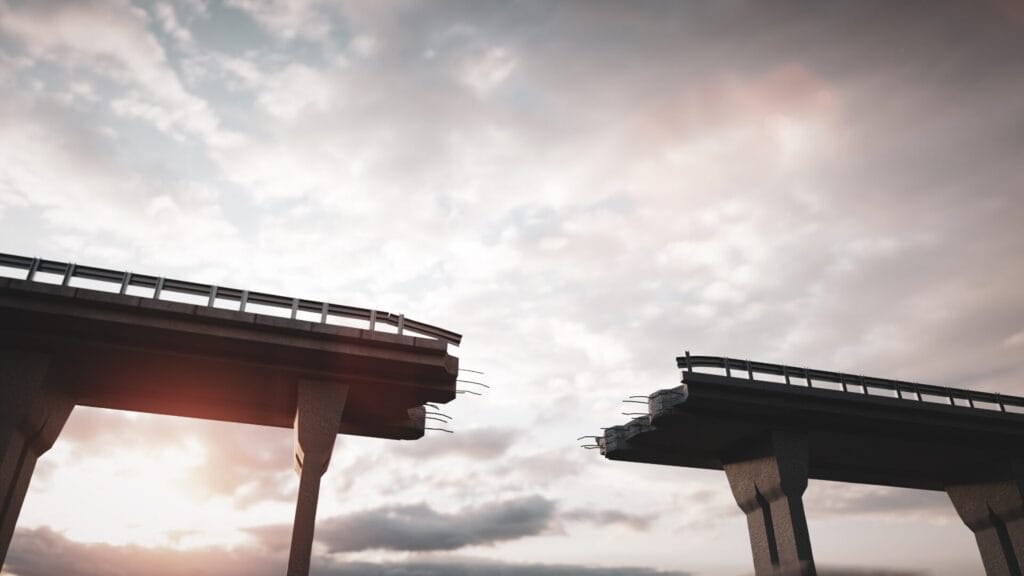 Broken bridge with a gap in the middle under a cloudy sky, symbolizing gaps in global marketing personalization strategies.